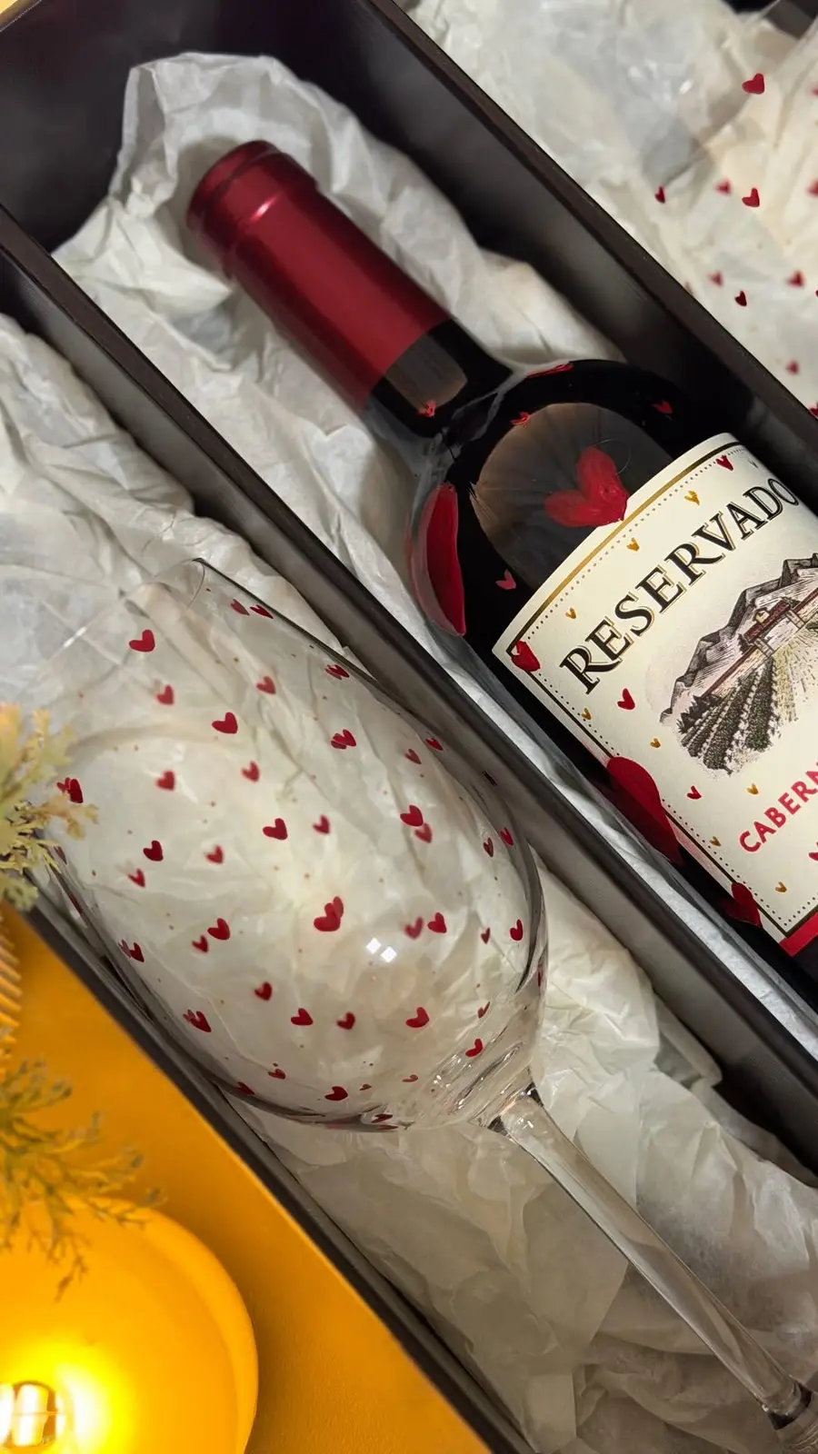 Kit da coleção cápsula aberto na caixa: taça de corações e vinho personalizado